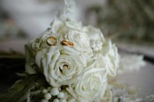 alianças de casamento em uma flor foto