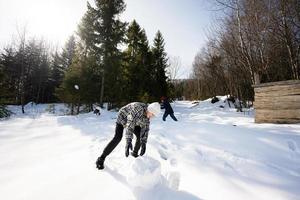 dois feliz Rapazes juntos esculpir neve globo para boneco de neve. irmãos jogos ao ar livre dentro inverno com neve dentro montanhas. foto