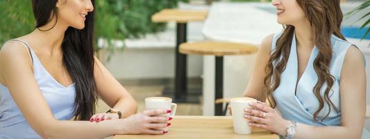 dois jovem mulheres beber café foto