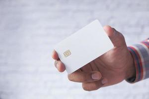 mão segurando um cartão de crédito branco foto