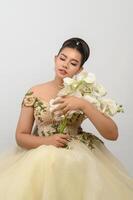 jovem noiva linda asiática com buquê de orquídeas em fundo branco foto