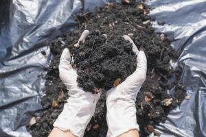 mãos segurando abundância solo para agricultura ou preparando para plantar teste solo amostras em mãos com solo terra fundo. sujeira qualidade e agricultura conceito. seletivo foco em Preto solo dentro frente foto