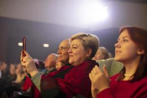 bielorrússia, cidade do gomil, abril 01, 2022. espectadores dentro a auditório assistindo a show, filmando em uma Smartphone.. foto