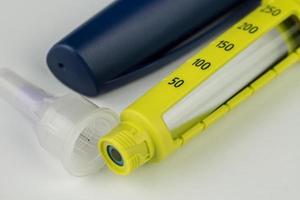 close-up de um injetor de insulina amarelo tipo caneta descartável