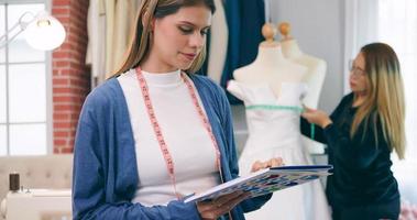 uma lindo mulher alfaiate fazer compras proprietário é indo para Projeto roupas para clientes. moda designers às trabalhos dentro estúdio. foto