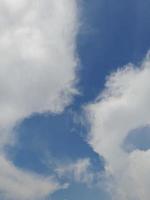 lindas nuvens brancas sobre fundo de céu azul profundo. grandes nuvens fofas e brilhantes cobrem todo o céu azul. foto