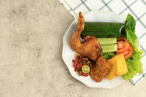 nasi tamboril com ayam goreng, frito tofu, e tempeh. foto