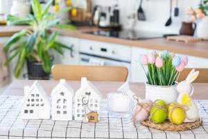 chave para casa do acolhedor casa com Páscoa decoração com Coelho e ovos em mesa do cozinha. prédio, projeto, projeto, comovente para Novo casa, hipoteca, seguro, renda e compra real Estado foto