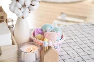 Páscoa decoração do colorida ovos dentro uma cesta e uma Coelho em a cozinha mesa dentro uma rústico estilo. festivo interior do uma país casa foto