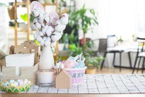 Páscoa decoração do colorida ovos dentro uma cesta e uma Coelho em a cozinha mesa dentro uma rústico estilo. festivo interior do uma país casa foto