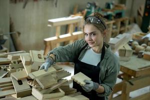jovem fêmea carpinteiro trabalhando projeto dentro dela oficina. fêmea carpinteiro fazer de madeira mobiliário. foto