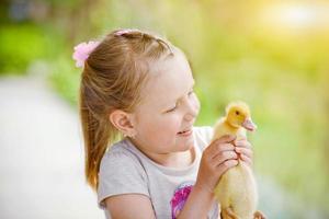 pequeno menina detém acima e fuma em uma Pato foto