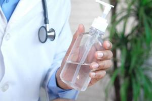 médico segurando frasco de desinfetante para as mãos foto
