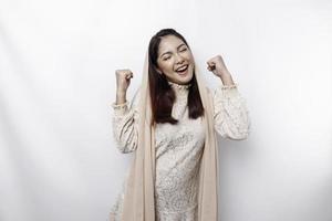 uma jovem muçulmana asiática com uma expressão feliz e bem-sucedida usando um hijab isolado por fundo branco foto