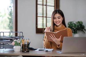 Aluna asiática Aluna de aprendizagem on-line Aula de estudo on-line com videochamada Professora de zoom, garota asiática feliz aprende inglês on-line com o laptop do computador. foto