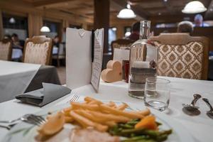 fechar-se do água e refeição servido em mesa dentro hotel foto