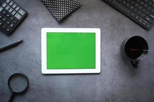 composição plana de tablet digital em fundo escuro de escritório foto