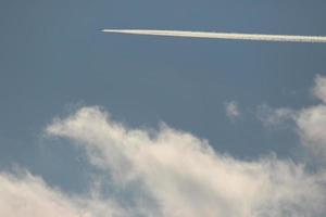 um avião e trilhas de vapor no céu foto