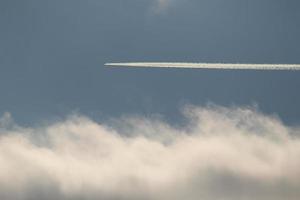 um avião e trilhas de vapor no céu foto