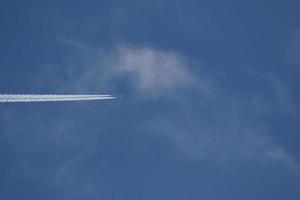 um avião e trilhas de vapor no céu foto