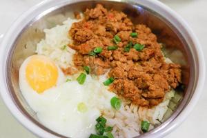 refogado carne de porco em arroz cozinhou e ovo em tigela ásia Comida foto