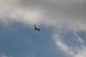 pequeno avião vôo dentro a céu contra Sombrio nuvens foto