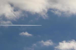 um avião e trilhas de vapor no céu foto