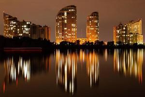 cidade noturna com reflexo de casas no rio foto