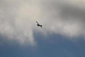 pequeno avião vôo dentro a céu contra Sombrio nuvens foto