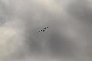 pequeno avião vôo dentro a céu contra Sombrio nuvens foto