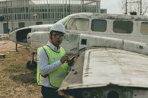 aeronave mecânico examinando avião asa foto