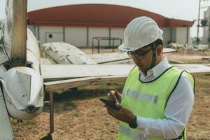 aeronave mecânico examinando avião asa foto