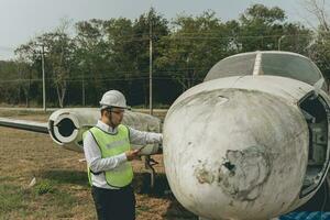 aeronave mecânico examinando avião asa foto