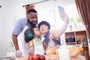 feliz africano americano família apreciar juntos enquanto preparar a farinha para fazer biscoitos às casa foto