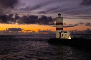 pôr do sol às a gardur velho farol dentro Islândia foto