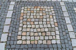 antigo padrão de pedras de pavimentação. textura de paralelepípedos alemão antigo no centro da cidade. pequenos ladrilhos de granito. pavimentos cinzas antigos. foto