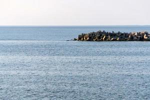 paisagem marítima de minimalismo. sonhos de viagem, copie o espaço. vista deslumbrante do mar com quebra-mares. águas calmas do mar azul. foto