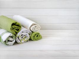 uma pilha do ordenadamente guardada toalhas em de madeira fundo. Produção do natural têxtil fibras.orgânicas produtos. natural pano foto