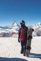 jovem snowboarder gastos inverno feriados dentro zermatt, perto a famoso matterhorn pico. masculino posando dentro suíço Alpes para a snowboard temporada. foto