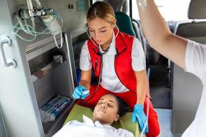 jovem médico com estetoscópio ouvindo paciente coração e pulmões. foto