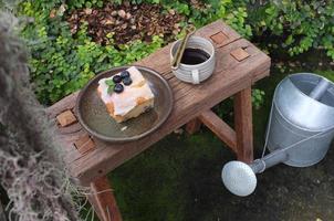 café com um pedaço de bolo na mesa de madeira foto
