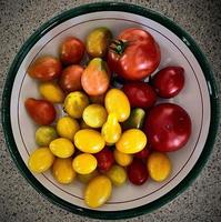 tomates lindos em uma tigela velha foto