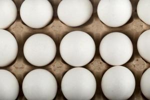 Ovos de galinha crus em uma caixa de ovos em um fundo de mármore foto