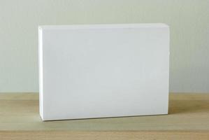 em branco branco cartão pacote caixa brincar em de madeira mesa foto