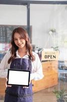 retrato do uma mulher, uma café fazer compras o negócio proprietário sorridente belas e abertura uma café fazer compras este é dela próprio negócios, pequeno o negócio conceito. foto