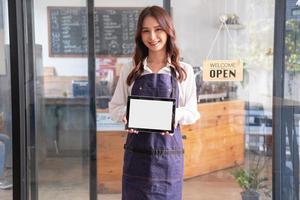 retrato do uma mulher, uma café fazer compras o negócio proprietário sorridente belas e abertura uma café fazer compras este é dela próprio negócios, pequeno o negócio conceito. foto