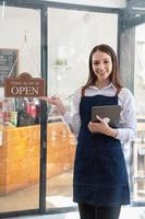 retrato do uma mulher, uma café fazer compras o negócio proprietário sorridente belas e abertura uma café fazer compras este é dela próprio negócios, pequeno o negócio conceito. foto