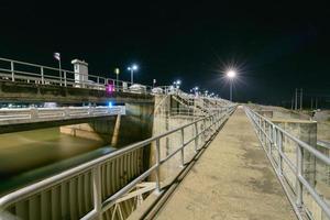 construção do vertedouro barragem portão em noite, a pa sak cholasit barragem foto