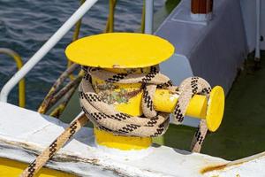 amarelo poste de amarração em a área coberta do uma barco com uma corda foto