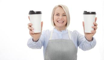 tempo parcial trabalho café pausa relaxar lazer pausa conceito. amigáveis agradável mulher barista dando dois grande café com leite isolado em cinzento fundo cópia-espaço foto